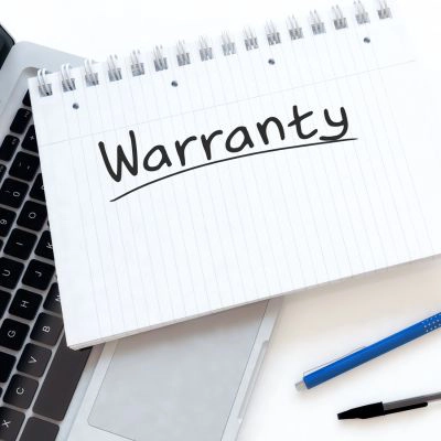 Photo of a computer with notepad lying on it. The word 'warranty' is on the notepad.