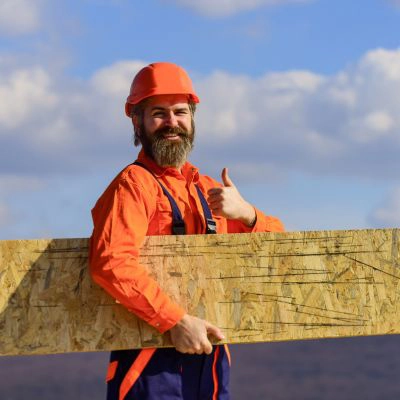Professional roofer holding a cut piece of OSB