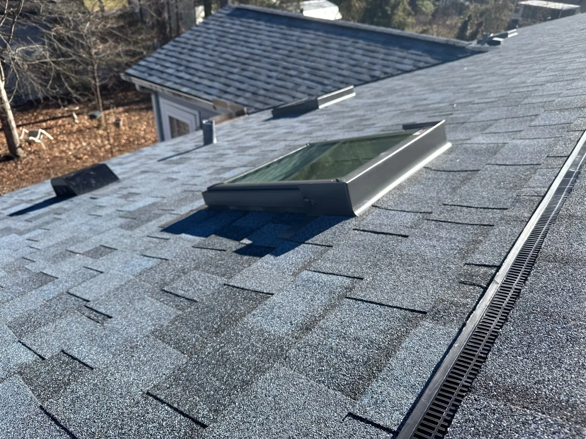 A newly installed skylight on an asphalt shingle roof by a local roofing company serving homes in Arden/Asheville, NC, and Greenville, SC.