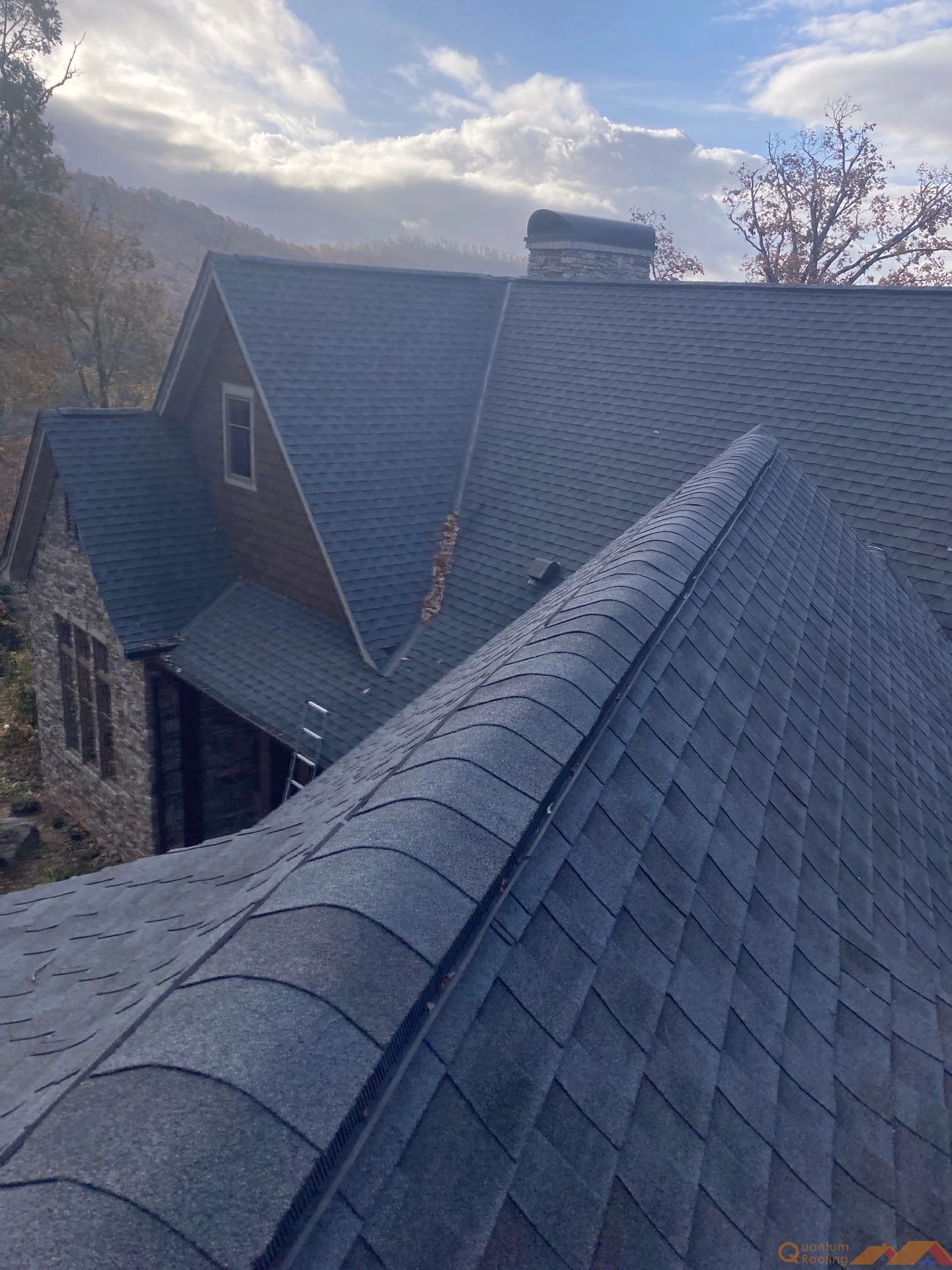 Before image of an aging residential roof in Asheville, NC showing worn shingles and complex rooflines prior to a full roof replacement.