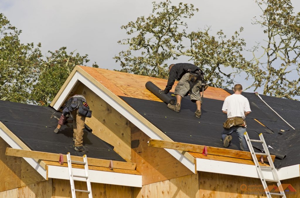 Three Roofing Contractors from Quantum Roofing performing a roof replacement in Hendersonville.