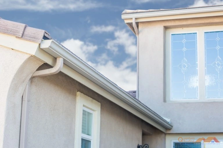 Newly installed rain gutters on a stucco home by a local roofing company providing custom gutter solutions in Arden/Asheville, NC, and Greenville, SC.
